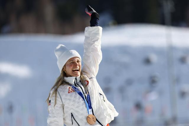 Bronze medallist USA's Jessie Diggins celebrates on the podium for the women's cross-country skiing 10km interval start free event of the Milano Cortina 2026 Winter Olympic Games at Tesero Cross-Country Skiing Stadium in Lago di Tesero (Val di Fiemme), on February 12, 2026. (Photo by Anne-Christine POUJOULAT / AFP)
