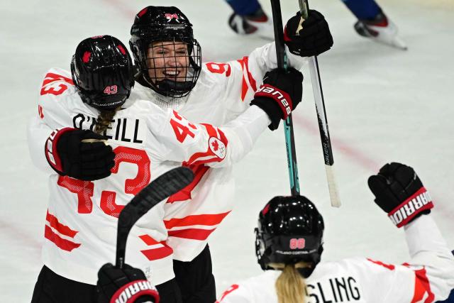Canada's forward #94 Jennifer Gardiner celebrates with Canada's forward #43 Kristin O'Neill after scoring during the women's preliminary round Group A Ice Hockey match between Finland and Canada at the Milano Rho Ice Hockey Arena during the Milano Cortina 2026 Winter Olympic Games in Milan, on February 12, 2026. (Photo by Piero CRUCIATTI / AFP)