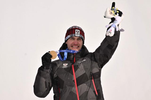 Gold medallist Austria's Alessandro Haemmerle celebrates on the podium after the snowboard men's cross final during the Milano Cortina 2026 Winter Olympic Games at Livigno Snow Park, in Livigno (Valtellina), on February 12, 2026. (Photo by Jeff PACHOUD / AFP)
