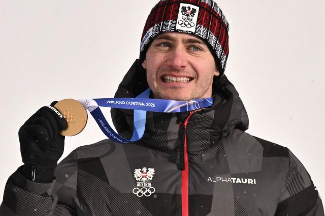 Gold medallist Austria's Alessandro Haemmerle celebrates on the podium after the snowboard men's cross final during the Milano Cortina 2026 Winter Olympic Games at Livigno Snow Park, in Livigno (Valtellina), on February 12, 2026. (Photo by Jeff PACHOUD / AFP)