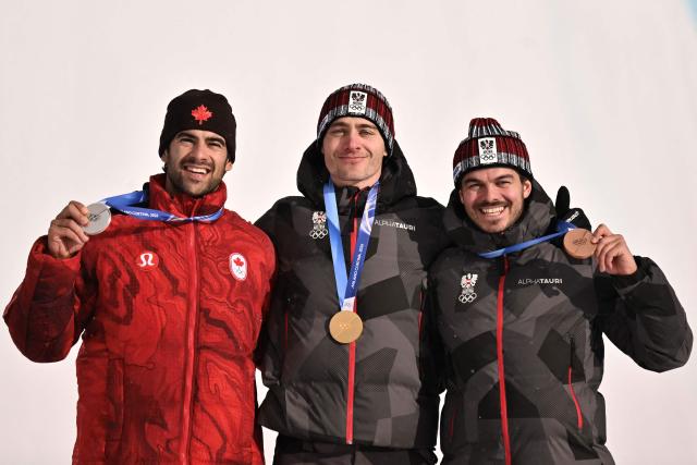 (From L) Silver medallist Canada's Eliot Grondin, gold medallist Austria's Alessandro Haemmerle and bronze medallist Austria's Jakob Dusek pose on the podium after the snowboard men's cross final during the Milano Cortina 2026 Winter Olympic Games at Livigno Snow Park, in Livigno (Valtellina), on February 12, 2026. (Photo by Jeff PACHOUD / AFP)
