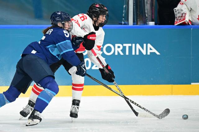 Finland's #05 Siiri Yrjola and Canada's forward #26 Emily Clark vie for the puck during the women's preliminary round Group A Ice Hockey match between Finland and Canada at the Milano Rho Ice Hockey Arena during the Milano Cortina 2026 Winter Olympic Games in Milan, on February 12, 2026. (Photo by Piero CRUCIATTI / AFP)
