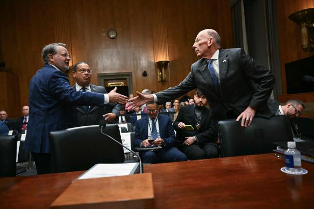 (L/R) Committee ranking member Senator Gary Peters, Democrat from Michigan greets Minnesota Attorney General Keith Ellison and Commissioner, Department of Corrections State of Minnesota Paul Schnell before they testify before the Senate Homeland Security and Governmental Affairs Committee in an oversight hearing amid scrutiny over immigration enforcement and recent developments in Minnesota at the Dirksen Senate Office Building in Washington, DC on February 12, 2026. (Photo by Brendan SMIALOWSKI / AFP)