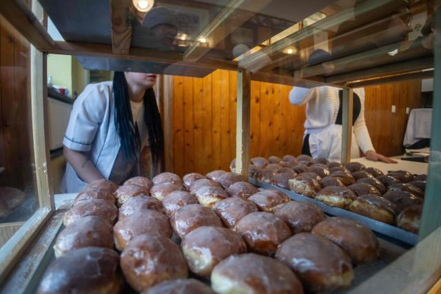 A tray with traditional, marmalade-filled "paczki" - doughnuts is displayed, in one of the most popular and believed to be the oldest "paczki" bakery in Warsaw, February 12, 2026. People spend over four hours to fulfill tradition and celebrate the end of carnival by eating "paczki". (Photo by Wojtek RADWANSKI / AFP)