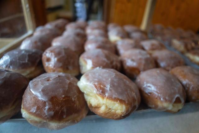 A tray with traditional, marmalade-filled "paczki" - doughnuts is displayed, in one of the most popular and believed to be the oldest "paczki" bakery in Warsaw, February 12, 2026. People spend over four hours to fulfill tradition and celebrate the end of carnival by eationg "paczki". (Photo by Wojtek RADWANSKI / AFP)