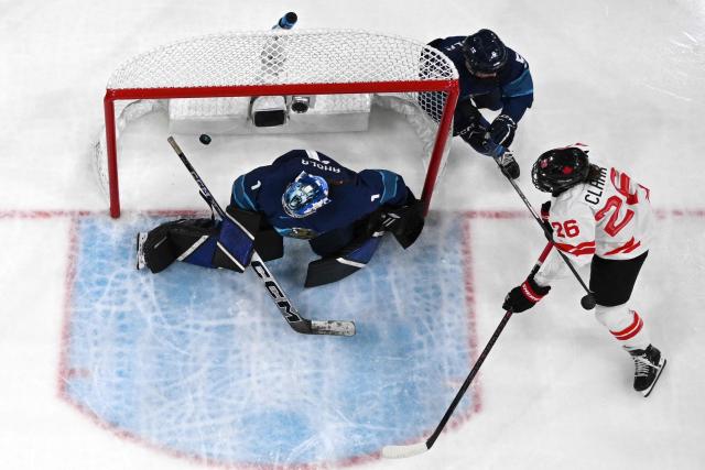 Canada's forward #26 Emily Clark scores her team fourth goal during the women's preliminary round Group A Ice Hockey match between Finland and Canada at the Milano Rho Ice Hockey Arena during the Milano Cortina 2026 Winter Olympic Games in Milan, on February 12, 2026. (Photo by Piero CRUCIATTI / AFP)