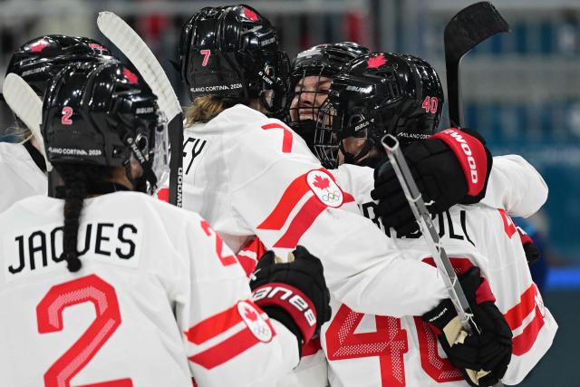 Canada's forward #26 Emily Clark celebrates with teammates after scoring a goal during the women's preliminary round Group A Ice Hockey match between Finland and Canada at the Milano Rho Ice Hockey Arena during the Milano Cortina 2026 Winter Olympic Games in Milan, on February 12, 2026. (Photo by Piero CRUCIATTI / AFP)