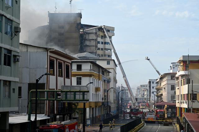 Firefighters battle a fire in an apartment tower in the central area of the bay of Guayaquil, Ecuador, on February 12, 2026. (Photo by MARCOS PIN / AFP)