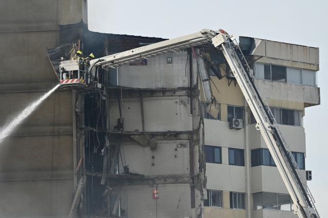 Firefighters battle a fire in an apartment tower in the central area of the bay of Guayaquil, Ecuador, on February 12, 2026. (Photo by MARCOS PIN / AFP)