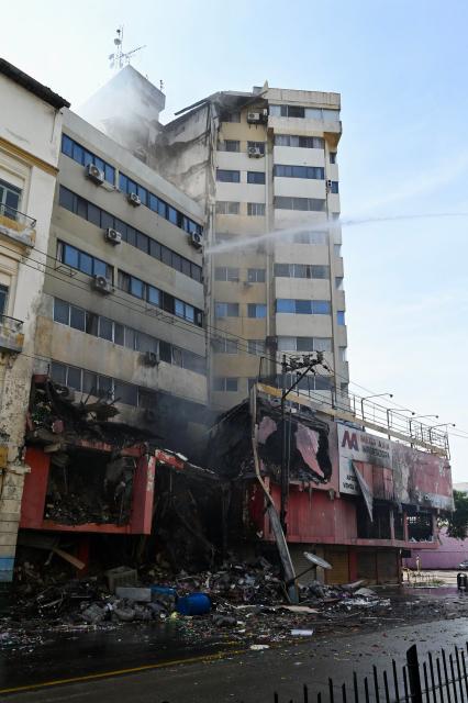 Firefighters battle a fire in an apartment tower in the central area of the bay of Guayaquil, Ecuador, on February 12, 2026. (Photo by MARCOS PIN / AFP)