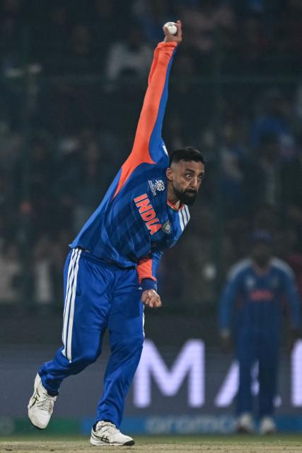 India's Varun Chakravarthy delivers a ball during the 2026 ICC Men's T20 Cricket World Cup group stage match between India and Namibia at the Arun Jaitley Stadium in New Delhi on February 12, 2026. (Photo by Arun SANKAR / AFP)