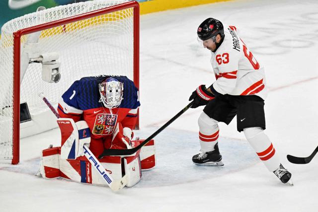 Canada's #63 Brad Marchand (R) shoots the puck that is saved by Czech Republic's #01 Lukas Dostal during the men's preliminary round Group A Ice Hockey match between Czech Republic and Canada at the Milano Santagiulia Ice Hockey Arena during the Milano Cortina 2026 Winter Olympic Games in Milan, on February 12, 2026. (Photo by Alexander NEMENOV / AFP)