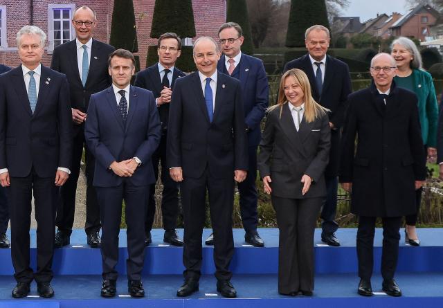 Italy's Prime Minister Giorgia Meloni (2R) reacts as she stands next to (From L-R) Lithuania's President Gitanas Nauseda, Germany's Chancellor Friedrich Merz, France's President Emmanuel Macron, Sweden's Prime Minister Ulf Kristersson, Ireland's Prime Minister Micheal Martin, Belgium's Prime Minister Bart De Wever, Poland's Prime Minister Donald Tusk, Luxembourg's Prime Minister Luc Frieden for a for a family photo as part of the Informal EU Leaders' Retreat at the Alden Biesen Castle, in Rijkhoven on February 12, 2026. (Photo by Ludovic MARIN / AFP)