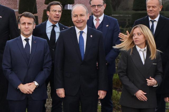 Italy's Prime Minister Giorgia Meloni (2R) reacts as she stands next to France's President Emmanuel Macron (L), Sweden's Prime Minister Ulf Kristersson (2L), Ireland's Prime Minister Micheal Martin (C), Belgium's Prime Minister Bart De Wever (3R) and Poland's Prime Minister Donald Tusk (R) for a for a family photo as part of the Informal EU Leaders' Retreat at the Alden Biesen Castle, in Rijkhoven on February 12, 2026. (Photo by Ludovic MARIN / AFP)