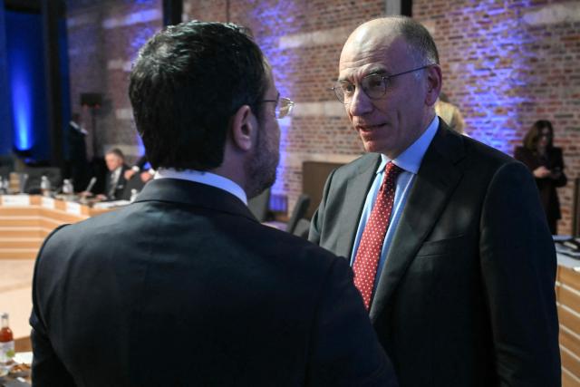 Former Prime Minister of Italy Enrico Letta (R) speaks with an attendee during a working session as part of the Informal EU Leaders' Retreat at the Alden Biesen Castle, in Rijkhoven on February 12, 2026. (Photo by NICOLAS TUCAT / POOL / AFP)