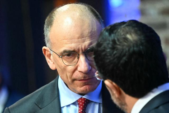 Former Prime Minister of Italy Enrico Letta (L) speaks with an attendee during a working session as part of the Informal EU Leaders' Retreat at the Alden Biesen Castle, in Rijkhoven on February 12, 2026. (Photo by NICOLAS TUCAT / POOL / AFP)