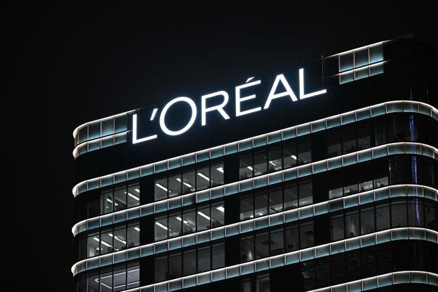 (FILES) A L'Oréal logo is seen on a building in the Jing'an district in Shanghai on November 4, 2025. French cosmetics giant L'Oreal reports a 4.4% drop in net profit to 6.13 billion euros, hit by currency effects and an exceptional surtax imposed on large companies to help restore France's public finances on February 12, 2026. (Photo by Hector RETAMAL / AFP)