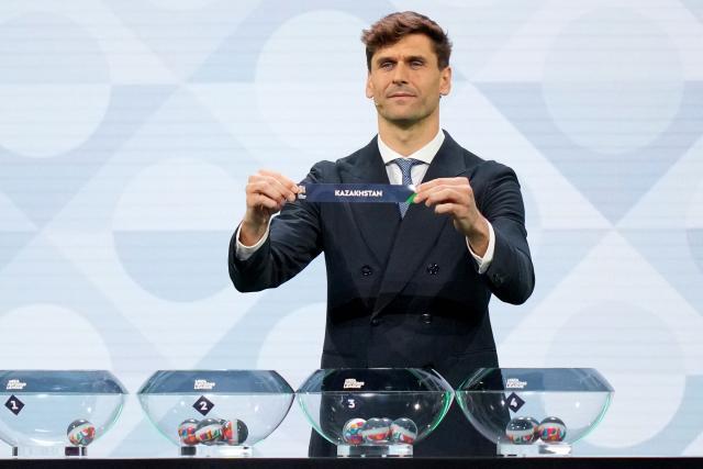 Former Spanish international Fernando Llorente shows up the paper slip for Kazakhstan during the 2026/27 UEFA Nations League league phase group C draw ceremony as part of the European football governing body's 50th annual Ordinary Congress in Brussels on February 12, 2026. (Photo by Pau BARRENA / AFP)