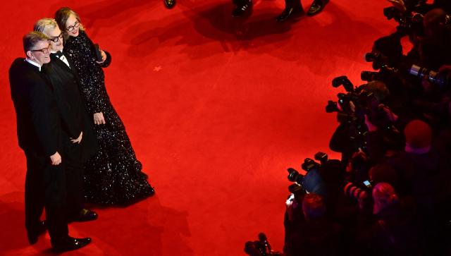 German film director Wim Wenders and his wife Donata Wenders pose with State Minister for Culture Wolfram Weimer as they arrive on the red carpet for the premiere of the film "No Good Men" presented in the Berlinale Special Gala section and opening the 76th Berlinale, Europe's first major film festival of the year, in Berlin on February 12, 2026. (Photo by John MACDOUGALL / AFP)