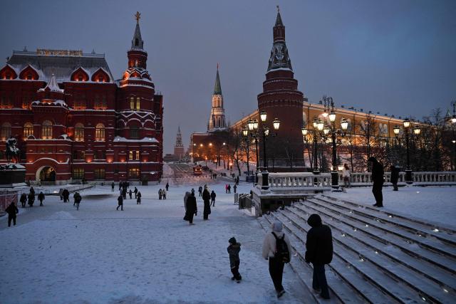 People walk near Kremlin in central Moscow on February 12, 2026. (Photo by Hector RETAMAL / AFP)
