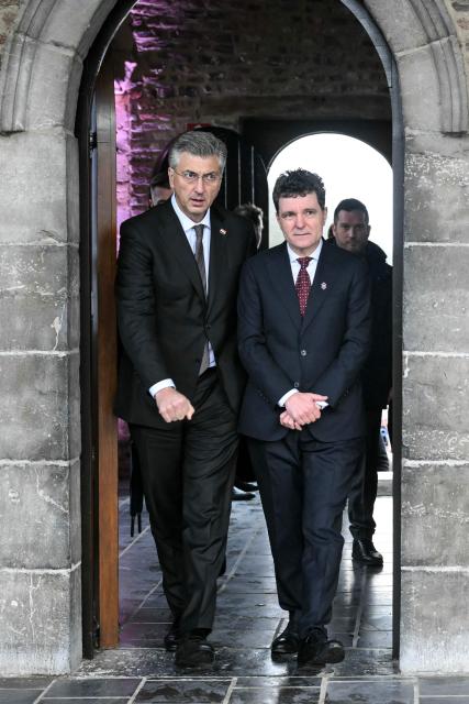 Croatia's Prime Minister Andrej Plenkovic (L) and Romania's President Nicusor Dan (R) arrive for a working session during the Informal EU Leaders' Retreat at the Alden Biesen Castle, in Rijkhoven on February 12, 2026. (Photo by NICOLAS TUCAT / AFP)