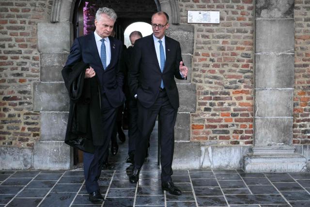 Lithuania's President Gitanas Nauseda (L) and Germany's Chancellor Friedrich Merz (R) arrive for a working session during the Informal EU Leaders' Retreat at the Alden Biesen Castle, in Rijkhoven on February 12, 2026. (Photo by NICOLAS TUCAT / AFP)