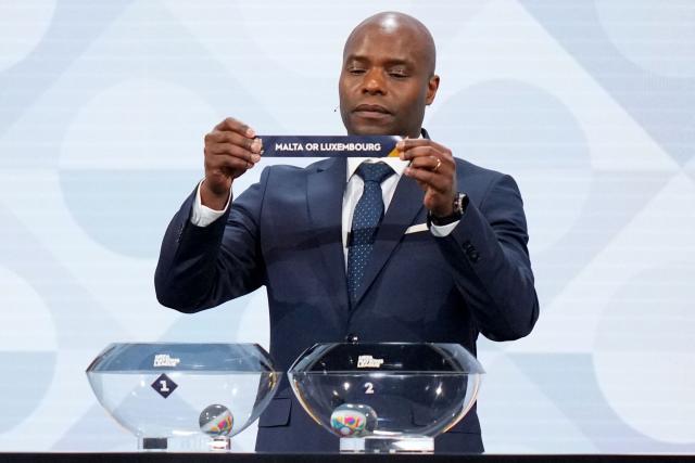 Former Belgium international Mbo Mpenza shows up the paper slip for Malta or Luxembourg during the 2026/27 UEFA Nations League league phase group D draw ceremony as part of the European football governing body's 50th annual Ordinary Congress in Brussels on February 12, 2026. (Photo by Pau BARRENA / AFP)