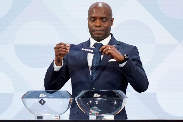 Former Belgium international Mbo Mpenza shows up the paper slip for Andorra during the 2026/27 UEFA Nations League league phase group D draw ceremony as part of the European football governing body's 50th annual Ordinary Congress in Brussels on February 12, 2026. (Photo by Pau BARRENA / AFP)