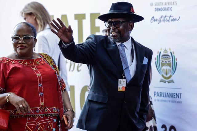 South African Minister of Finance Enoch Godongwana (R) gestures as he arrives to attend the State of the Nation (SONA) address in Cape Town on February 12, 2026. (Photo by Gianluigi GUERCIA / AFP)