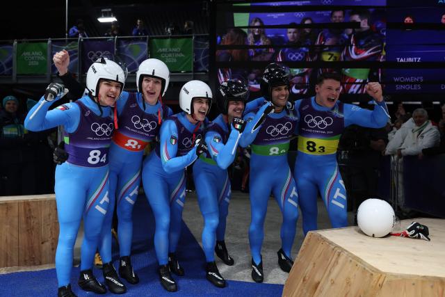 Italy's Andrea Voetter, Italy's Verena Hofer, Italy's Marion Oberhofer, Italy's Emanuel Rieder, Italy's Simon Kainzwaldner and Italy's Dominik Fischnaller celebrate after competing in the luge team mixed relay at Cortina Sliding Centre during the Milano Cortina 2026 Winter Olympic Games in Cortina d'Ampezzo on February 12, 2026. (Photo by FRANCK FIFE / AFP)