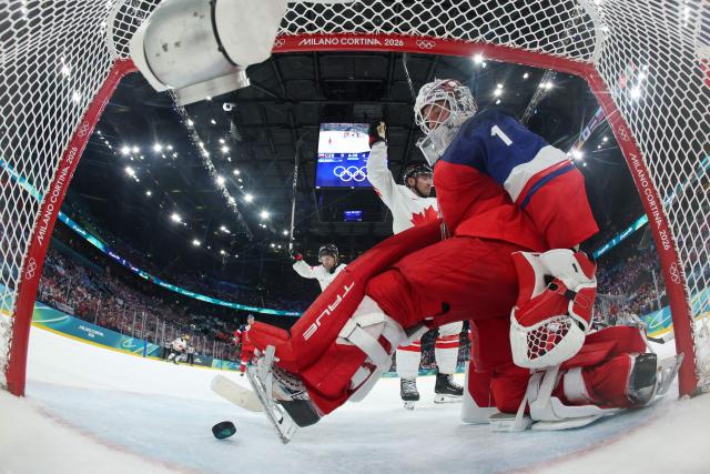 Czech Republic's #01 Lukas Dostal receives the fifth goal scored by Canada's #10 Nick Suzuki (behind) during the men's preliminary round Group A Ice Hockey match between Czech Republic and Canada at the Milano Santagiulia Ice Hockey Arena during the Milano Cortina 2026 Winter Olympic Games in Milan, on February 12, 2026. (Photo by POOL / AFP)