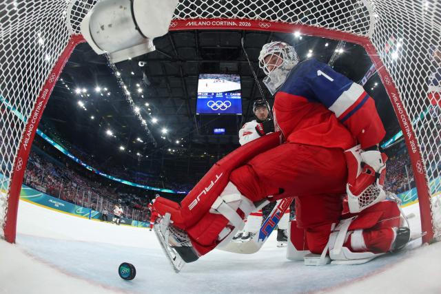 Czech Republic's #01 Lukas Dostal receives the fifth goal scored by Canada's #10 Nick Suzuki (behind) during the men's preliminary round Group A Ice Hockey match between Czech Republic and Canada at the Milano Santagiulia Ice Hockey Arena during the Milano Cortina 2026 Winter Olympic Games in Milan, on February 12, 2026. (Photo by POOL / AFP)