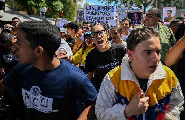 University students, opponents of the government, shout slogans during a march on the Youth Day in Caracas on February 12, 2026. The first major opposition demonstration after the fall of Nicolas Maduro during a US military incursion a month ago gathered thousands of people in Venezuelas capital on February 12, ahead of the approval of a historic amnesty law. (Photo by Juan BARRETO / AFP)