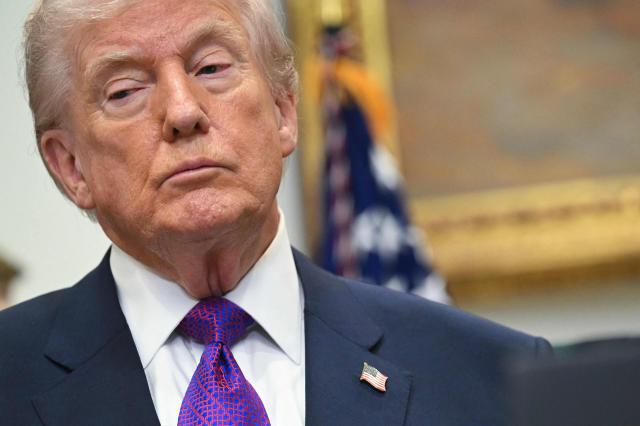 US President Donald Trump looks on during an announcement in the Roosevelt Room of the White House in Washington, DC on February 12, 2026. President Donald Trump on Thursday revoked a landmark scientific finding that underpins US regulations aimed at curbing planet-warming pollution, marking the administration's most far-reaching rollback of climate policy to date. (Photo by SAUL LOEB / AFP)