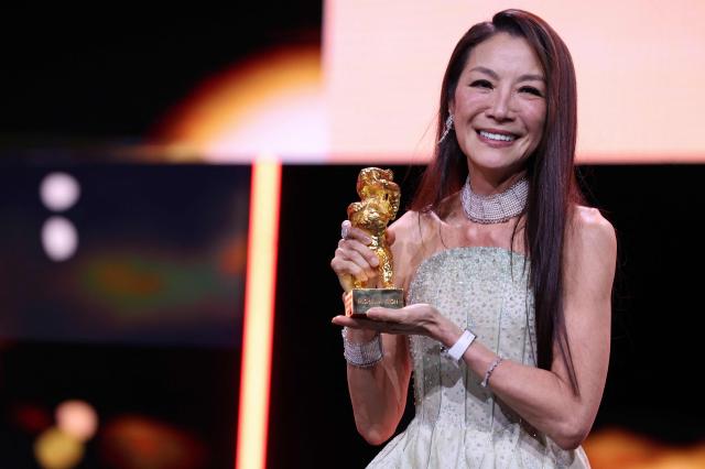 Malaysian actress Michelle Yeoh holds the trophy after being awarded the Honorary Golden Bear during the opening ceremony of the 76th Berlinale, Europe's first major film festival of the year, in Berlin on February 12, 2026. Yeoh is awarded the prize "in recognition of her outstanding achievements in film and cinema". (Photo by Ronny HARTMANN / AFP)