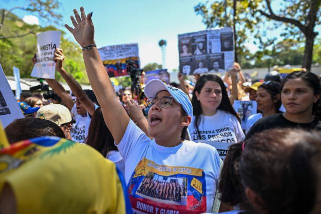 University students, opponents of the government, and relatives of political prisoners, shout slogans during a march on the Youth Day in Caracas on February 12, 2026. The first major opposition demonstration after the fall of Nicolas Maduro during a US military incursion a month ago gathered thousands of people in Venezuelas capital on February 12, ahead of the approval of a historic amnesty law. (Photo by Juan BARRETO / AFP)