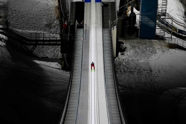 Austria's Jan Hoerl slides down the inrun track during the men's ski jumping large hill training of the Milano Cortina 2026 Winter Olympic Games at Predazzo Ski Jumping Stadium in Predazzo (Val di Fiemme), on February 12, 2026. (Photo by Tobias SCHWARZ / AFP)