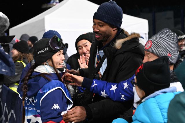 USA's Chloe Kim and Cleveland Browns defensive end Myles Garrett react in the snowboard women's halfpipe final run 2 during the Milano Cortina 2026 Winter Olympic Games at Livigno Snow Park, in Livigno (Valtellina), on February 12, 2026. (Photo by Kirill KUDRYAVTSEV / AFP)