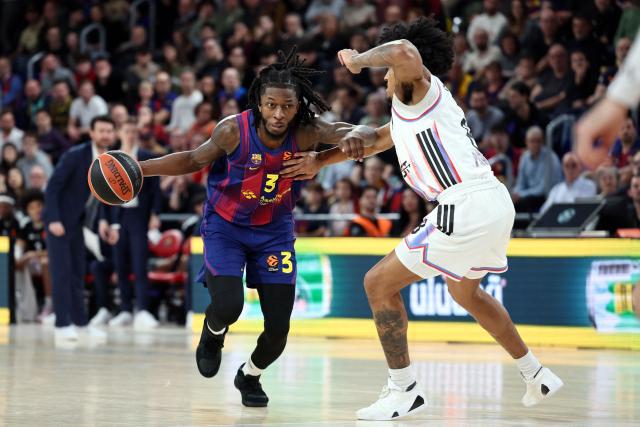 Barcelona's US forward #03 Myles Cale drives the ball guarded by Paris Basketball's US guard #08 Jared Rhoden during the Euroleague basketball match between FC Barcelona and Paris Basketball at Palau Blaugrana arena in Barcelona on February 12, 2026. (Photo by Josep LAGO / AFP)