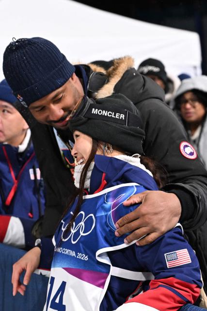 USA's Chloe Kim and Cleveland Browns defensive end Myles Garrett react in the snowboard women's halfpipe final run 2 during the Milano Cortina 2026 Winter Olympic Games at Livigno Snow Park, in Livigno (Valtellina), on February 12, 2026. (Photo by Kirill KUDRYAVTSEV / AFP)