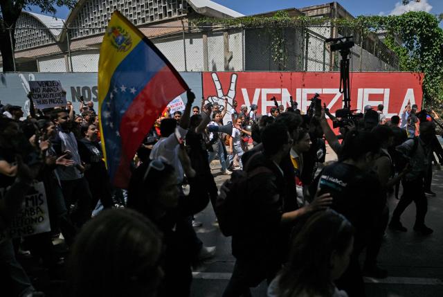 University students, opponents of the government, and relatives of political prisoners, take part in a march on the Youth Day in Caracas on February 12, 2026. The first major opposition demonstration after the fall of Nicolas Maduro during a US military incursion a month ago gathered thousands of people in Venezuelas capital on February 12, ahead of the approval of a historic amnesty law. (Photo by Juan BARRETO / AFP)