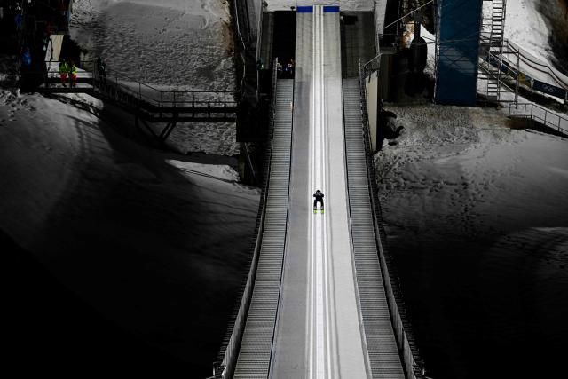 Japan's Ren Nikaido slides down the inrun track during the men's ski jumping large hill training of the Milano Cortina 2026 Winter Olympic Games at Predazzo Ski Jumping Stadium in Predazzo (Val di Fiemme), on February 12, 2026. (Photo by Tobias SCHWARZ / AFP)
