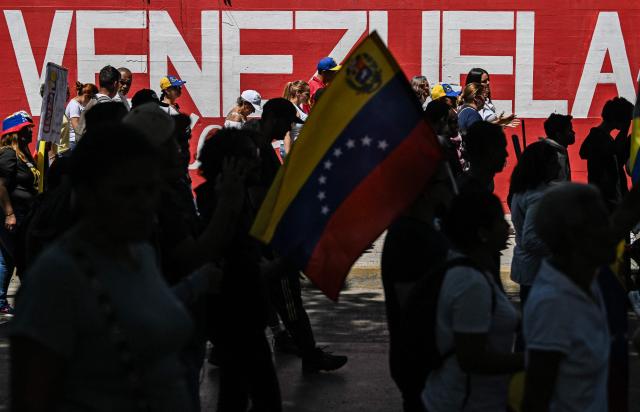 University students, opponents of the government, and relatives of political prisoners, take part in a march on the Youth Day in Caracas on February 12, 2026. The first major opposition demonstration after the fall of Nicolas Maduro during a US military incursion a month ago gathered thousands of people in Venezuelas capital on February 12, ahead of the approval of a historic amnesty law. (Photo by Juan BARRETO / AFP)