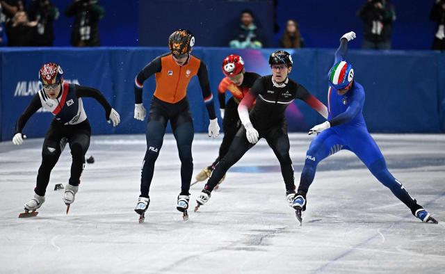 South Korea's Rim Jong-un (L), Netherlands' Jens van 't Wout (2L) and Italy's Luca Spechenhauser (R) approach the finish line in the short track speed skating men's 1000m quarter-final during the Milano Cortina 2026 Winter Olympic Games at Milano Ice Skating Arena in Milan on February 12, 2026. (Photo by Gabriel BOUYS / AFP)