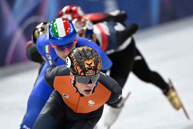 Netherlands' Jens van 't Wout and Italy's Luca Spechenhauser compete in the short track speed skating men's 1000m quarter-final during the Milano Cortina 2026 Winter Olympic Games at Milano Ice Skating Arena in Milan on February 12, 2026. (Photo by Gabriel BOUYS / AFP)