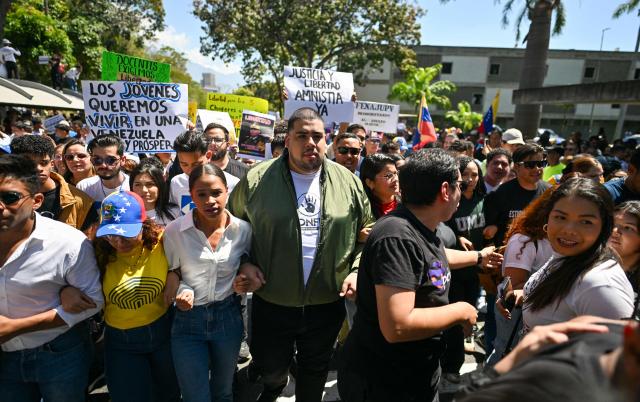 University students, opponents of the government, and relatives of political prisoners, take part in a march on the Youth Day in Caracas on February 12, 2026. The first major opposition demonstration after the fall of Nicolas Maduro during a US military incursion a month ago gathered thousands of people in Venezuelas capital on February 12, ahead of the approval of a historic amnesty law. (Photo by Juan BARRETO / AFP)