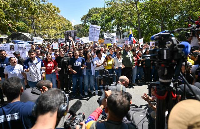 University students, opponents of the government, and relatives of political prisoners, take part in a march on the Youth Day in Caracas on February 12, 2026. The first major opposition demonstration after the fall of Nicolas Maduro during a US military incursion a month ago gathered thousands of people in Venezuelas capital on February 12, ahead of the approval of a historic amnesty law. (Photo by Juan BARRETO / AFP)