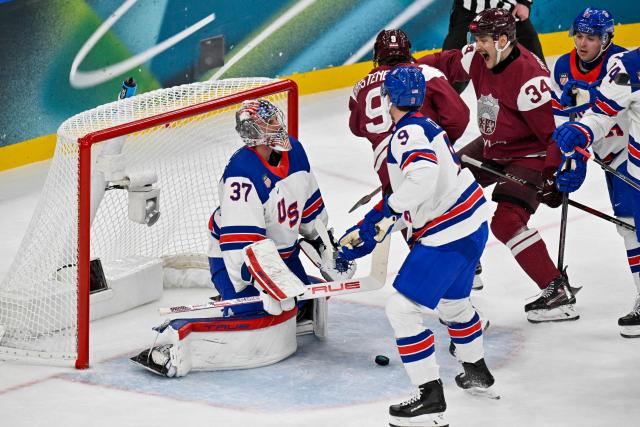 Latvia's #09 Renars Krastenbergs (C) scores the 1-1 goal past USA's #37 Connor Hellebuyck during the men's preliminary round Group C Ice Hockey match between Latvia and USA at the Milano Santagiulia Ice Hockey Arena during the Milano Cortina 2026 Winter Olympic Games in Milan, on February 12, 2026. (Photo by Alexander NEMENOV / AFP)