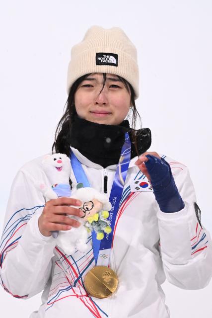 Gold medallist South Korea's Choi Gaon celebrates on the podium after the snowboard women's halfpipe final during the Milano Cortina 2026 Winter Olympic Games at Livigno Snow Park, in Livigno (Valtellina), on February 12, 2026. (Photo by Kirill KUDRYAVTSEV / AFP)