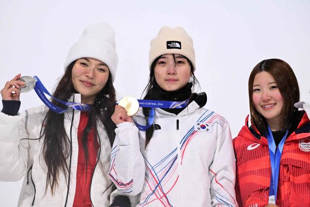 (From L) Silver medallist USA's Chloe Kim, gold medallist South Korea's Choi Gaon and bronze medallist Japan's Mitsuki Ono celebrate on the podium after the snowboard women's halfpipe final during the Milano Cortina 2026 Winter Olympic Games at Livigno Snow Park, in Livigno (Valtellina), on February 12, 2026. (Photo by Kirill KUDRYAVTSEV / AFP)